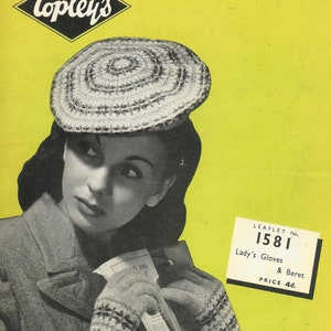 以下が含まれることがあります： 白黒の写真で、女性が白とグレーのニットのベレー帽と手袋を着用しています。女性は「LEAFLET No. 1581 Lady's Gloves & Beret PRICE 4d.」と書かれたチラシを持っています。