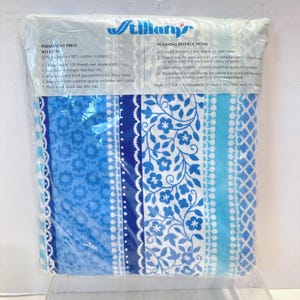 Puede incluir: Un juego de sábanas empaquetado con un estampado floral y a rayas azul y blanco. El embalaje incluye la marca "St. Mary's" e instrucciones de lavado. El juego de sábanas está hecho de una mezcla de poliéster y algodón.