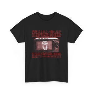 Può includere: T-shirt nero con un design grafico raffigurante un microonde con un teschio all'interno. Il testo recita "THE BODY WANDERS AND FROLICS" e "YET THE SOUL IS TRAPPED INSIDE A MICROWAVE".