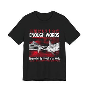 Puede incluir: Una camiseta negra con un gráfico de dos peces espada frente a frente sobre un fondo rojo. El texto dice "言葉はもう十分だ", "ENOUGH WORDS", "Now we test the strength of our ideals" y "今こそ、我らの理想の強さを測る時だ".