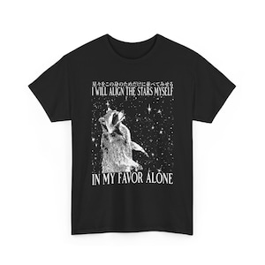 May include: Black t-shirt featuring a badger illustration under a starry sky. The text reads "I WILL ALIGN THE STARS MYSELF" and "IN MY FAVOR ALONE" in white. The shirt is a classic crew neck style.