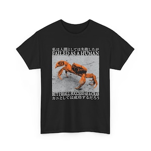 May include: Black t-shirt featuring a graphic of an orange crab on a gray background. The text "FAILED AS A HUMAN" and "BUT I SHALL SUCCEED AS A CRAB" are printed above and below the crab illustration.