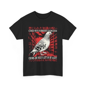 May include: Black t-shirt featuring a detailed illustration of a pigeon with a red and white background. The shirt includes the text "CURSED WITH FORBIDDEN KNOWLEDGE" and "CRUMBS ARE WHAT'S LEFT OF MY SANITY" in English and Japanese.