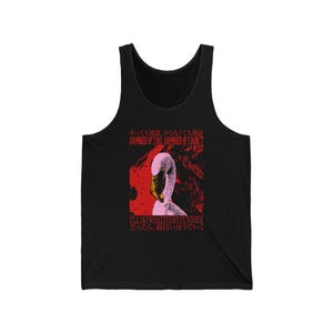 Peut inclure: Un débardeur noir avec une impression graphique représentant une tête de flamant rose sur fond rouge. Le texte indique : "DAMNED IF I DO, DAMNED IF I DON'T" et "I'LL DO WHATEVER'S FUNNIER" avec des caractères japonais au-dessus et en dessous.