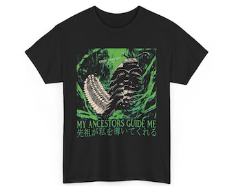 Può includere: T-shirt nera con una grafica verde e bianca di una grande creatura simile a un insetto. Il testo "MY ANCESTORS GUIDE ME" e testo giapponese sono stampati sotto la grafica. La maglietta è realizzata in materiale morbido.