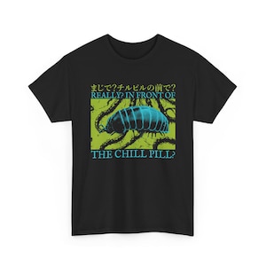 May include: Black t-shirt with a teal and blue graphic of a pill bug and the text "REALLY? IN FRONT OF THE CHILL PILL?" in teal and Japanese characters. The graphic is set against a green background.