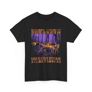 May include: Black t-shirt featuring a crab graphic in orange and purple, with the text "OUR DESTINIES ARE ONE AND THE SAME" and "FATED TO EVOLVE INTO CRABS". The design includes Japanese text. A casual, graphic tee.