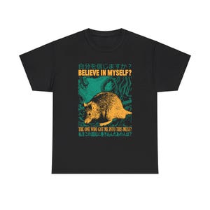May include: Black t-shirt with a graphic of a rat in a green and yellow forest scene. The text "自分を信じますか? BELIEVE IN MYSELF?" and "THE ONE WHO GOT ME INTO THIS MESS? 私をこの混乱に巻き込んだあの人は?" is printed on the shirt.