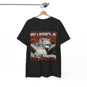 May include: Black t-shirt featuring a graphic print of a bat in front of a fiery background. The text "Today is for Jolly Nonsense, What a Wonderful Day!" is printed in white on the shirt. The text is in Japanese and English.