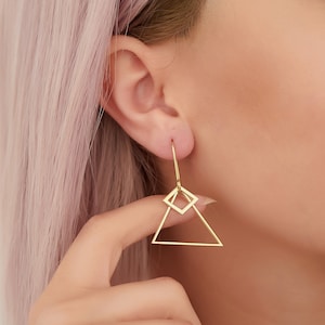 May include: Gold geometric earrings with a triangle and square design.
