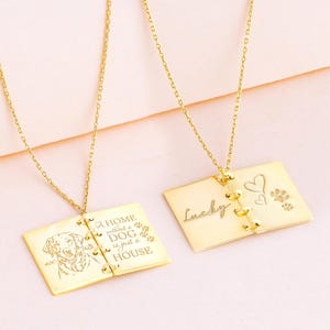 May include: Two gold-colored pendant necklaces. One pendant reads "HOME without a DOG is just a HOUSE" with a dog illustration. The other pendant says "Lucky" with heart and paw print designs. Both hang from delicate chains.