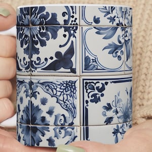 May include: A white ceramic mug with a blue and white tile pattern. The pattern features floral designs and geometric shapes.