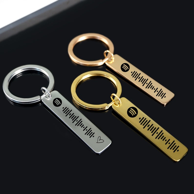 May include: Three keychains with different colored metal rings and bar-shaped charms. Each charm has a unique barcode pattern and a small music note symbol. The charms are engraved with the words "I love you".