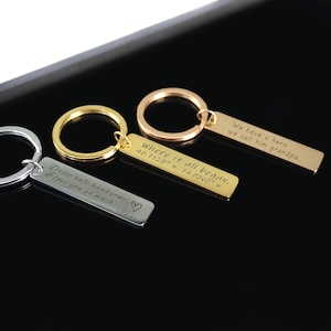 May include: Three silver, gold, and rose gold keychains with engraved messages. The silver keychain says "Drive safe handsome. I love you so much -Emma". The gold keychain says "Where it all began. 40.7128&deg; N, 74.0060&deg; W". The rose gold keychain says "We have a hero we call him grandpa."