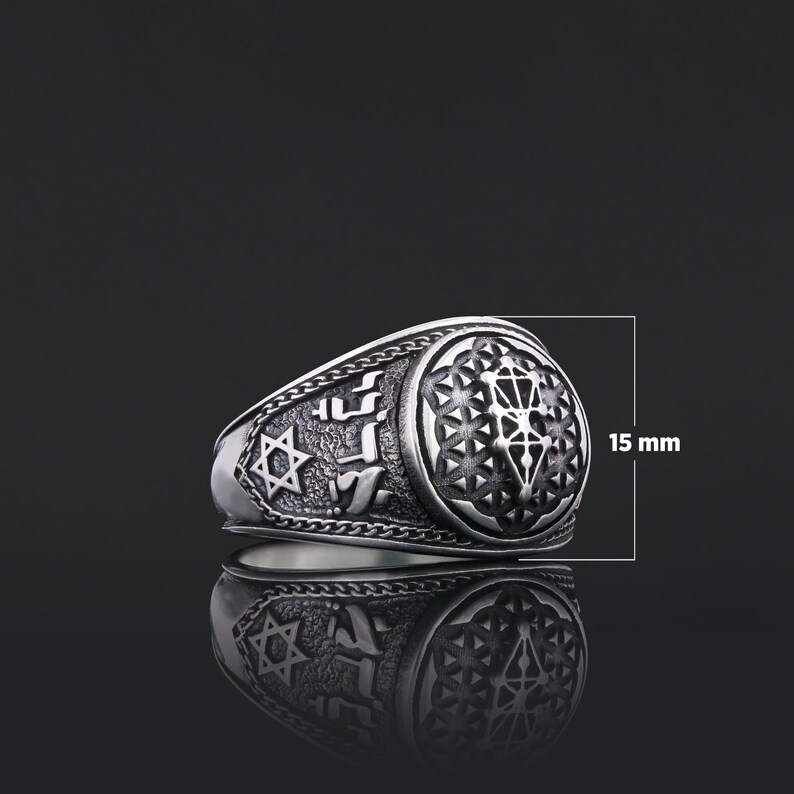 Op de afbeelding: Een zilveren ring met een gedetailleerd ontwerp met een Davidster, Hebreeuwse tekst en een geometrisch patroon. De ring is 15 mm breed.