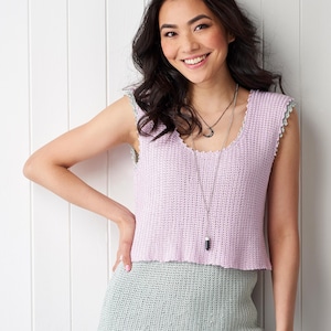 May include: A sleeveless, pale purple crochet top with a scalloped edge is shown. The top is paired with a light green skirt. The image includes a pink circular graphic with the text "Simply Knitting & Crochet PDF PATTERNS".