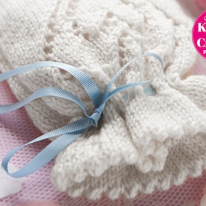 May include: A white crocheted drawstring bag with a blue ribbon tied around it. The bag is sitting on a pink and white patterned surface. The text "Simply Knitting & Crochet PDF Patterns" is visible in the upper right corner of the image.