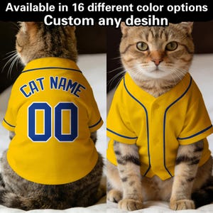 Może przedstawiać: Dwa zdjęcia kota w żółtej koszulce baseballowej z niebieskimi wykończeniami. Na plecach kota napis "CAT NAME" nad numerem "00". Tekst u góry brzmi "Dostępne w 16 różnych opcjach kolorystycznych Niestandardowy dowolny projekt".