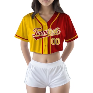 Puede incluir: Una camiseta de béisbol recortada con un esquema de color amarillo y rojo. La camiseta tiene un cuello en V blanco y un cierre de botones en la parte delantera. El texto "Teamtext" está impreso en dorado en la parte delantera de la camiseta, con el número "00" impreso en dorado en el lado derecho de la camiseta.