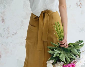 Falda midi cruzada de lino con bolsillos, cintura alta, estilo minimalista para el verano.