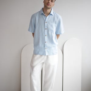 Man wearing FLORIDA white linen pants, showcasing a smart casual summer look, paired with a simple shirt.