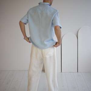 Back view of men's white linen FLORIDA pants, highlighting the waistband with strips for an adjustable and comfortable fit.