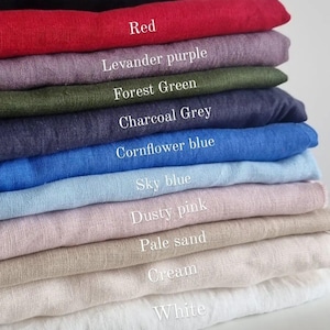 Puede incluir: Un conjunto de 12 muestras de tela en varios colores, incluyendo negro, rojo, lavanda púrpura, verde bosque, gris carbón, azul aciano, azul cielo, rosa polvoriento, arena pálida, crema y blanco.