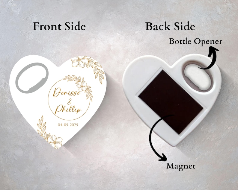 Może przedstawiać: Biały otwieracz do butelek w kształcie serca z magnesem z tyłu. Przednia strona zawiera złoty wz&oacute;r kwiatowy i tekst "Denise & Phillip 04.05.2025".