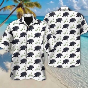 May include: A short-sleeve button-down shirt with a white base color featuring a repeating pattern of black wild boars and small green grass tufts. The garment has a classic collar, a front button placket, and a straight hemline design.