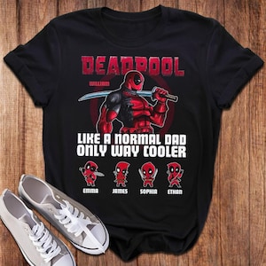 May include: Black t-shirt featuring a red and black Deadpool character graphic. The text "Deadpool William" is above the character. The text "Like a normal dad only way cooler" is below the character. Four smaller Deadpool characters are below the text with the names "Emma", "James", "Sophia", and "Ethan" underneath.