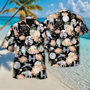 May include: Black button-down shirt with a floral and Star Wars-themed pattern. The design includes Stormtrooper helmets, Darth Vader, and X-wing fighters, interspersed with pink and white flowers. The shirt has short sleeves and a classic collar.