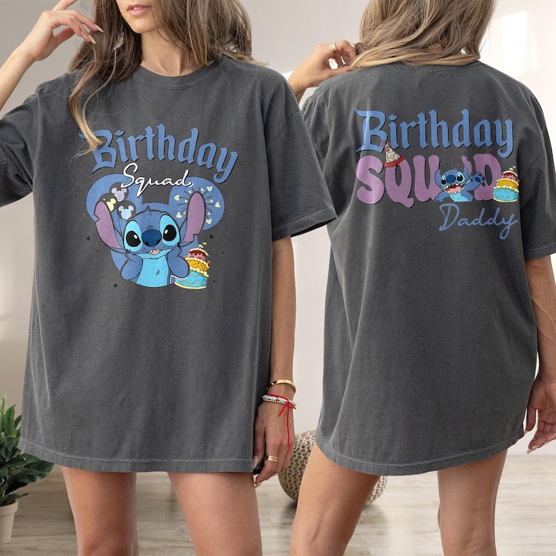 以下が含まれることがあります： グレーのTシャツで、前面に青いスティッチのキャラクターと「Birthday Squad」の文字が書かれています。Tシャツの背面には「Birthday Squad Daddy」の文字が書かれています。