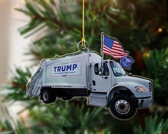 Może przedstawiać: Przezroczysta akrylowa ozdoba choinkowa w kształcie białej śmieciarki. Na ciężarówce widnieje napis "TRUMP" oraz hasło "MAKE AMERICA GREAT AGAIN! 2024". Dołączona jest amerykańska flaga i mała niebieska flaga.