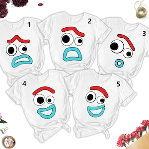 May include: Five white t-shirts with different facial expressions printed on them. The expressions include a surprised face, a sad face, a confused face, a happy face, and a face with a pacifier. The shirts are numbered 1 through 5.