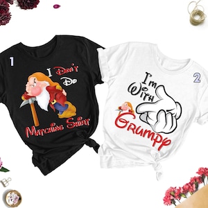 May include: Two black and white t-shirts with a matching design. The black shirt features a cartoon of Grumpy from Snow White and the text "I Don't Do Matching Shirts". The white shirt features a cartoon hand with the text "I'm With Grumpy".