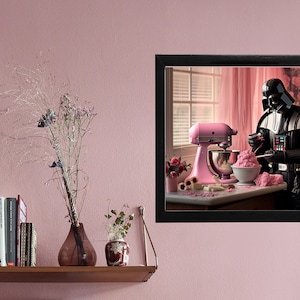 Könnte beinhalten: Darth Vader, eine fiktive Figur aus Star Wars, befindet sich in einer Küche und verwendet eine rosa Küchenmaschine und einen Spatel, um rosa Zuckerguss zu verrühren. Die Küchenmaschine steht auf einer Arbeitsplatte mit einer Schüssel rosa Zuckerguss und einer Tapete mit Blumenmuster im Hintergrund.