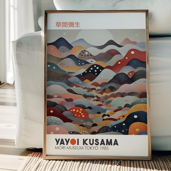 May include: A framed art print featuring a colorful abstract landscape design with rolling hills in shades of red, blue, and orange. The print includes Japanese text at the top and the artist's name, Yayoi Kusama, and the Mori Museum Tokyo 1985 at the bottom.