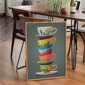 May include: A stack of colourful teacups with floral designs, stacked on top of each other. The cups are on a blue background and are framed in a wooden frame.