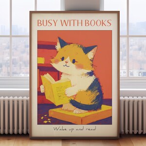 May include: A poster with a cute cartoon cat reading a book. The poster has a red background with the text "Busy with Books" at the top and "Wake up and read!" at the bottom.