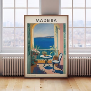 May include: A vintage travel poster with the word "MADEIRA" in bold, white letters on a pink background. The poster depicts a balcony overlooking a blue ocean with a table and chairs on the balcony. There are green plants and flowers on the balcony. The poster has the words "TRAVEL JOURNAL" at the bottom.