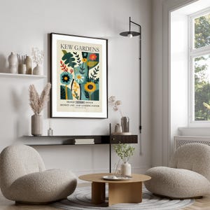 May include: A framed art print featuring a colorful floral design with the text "KEW GARDENS". The artwork includes stylized flowers, leaves, and the text "NEAREST UNDERGROUND STATION DISTRICT LINE | KEW GARDENS STATION". The print is displayed in a modern living room setting.