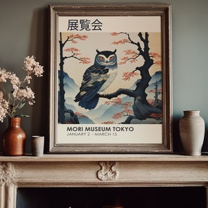 K&ouml;nnte beinhalten: Ein Vintage-Poster mit einer japanischen Eule, die auf einem Ast sitzt. Das Poster ist in einem braunen Holzrahmen gerahmt und tr&auml;gt oben den Text "展覧会" (Ausstellung) und unten "MORI MUSEUM TOKYO JANUARY 2 - MARCH 15".