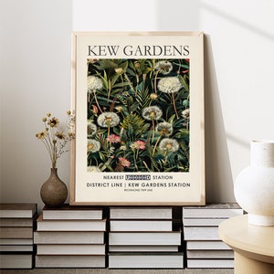 May include: A framed print with a botanical illustration of dandelions and other plants on a dark green background. The print has the text "KEW GARDENS" at the top and "NEAREST UNDERGROUND STATION DISTRICT LINE | KEW GARDENS STATION RICHMOND TW9 3AE" at the bottom.