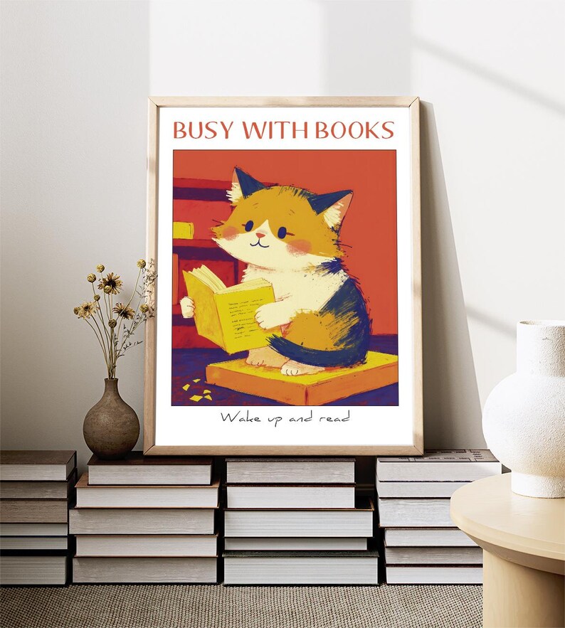 May include: A framed illustration of a cat reading a book. The cat is sitting on a stack of books. The text on the image reads "Busy with Books" and "Wake up and read".