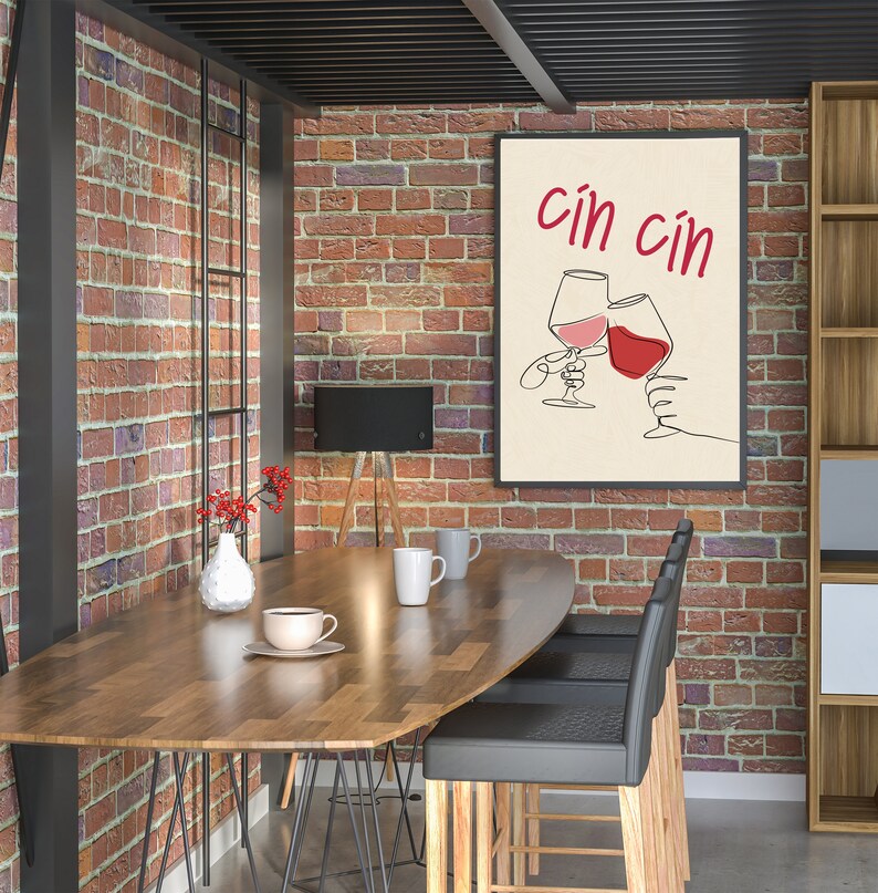 May include: A modern dining room with a wooden table and black chairs. A framed print with the text "cin cin" and a drawing of two wine glasses clinking together hangs on a brick wall.