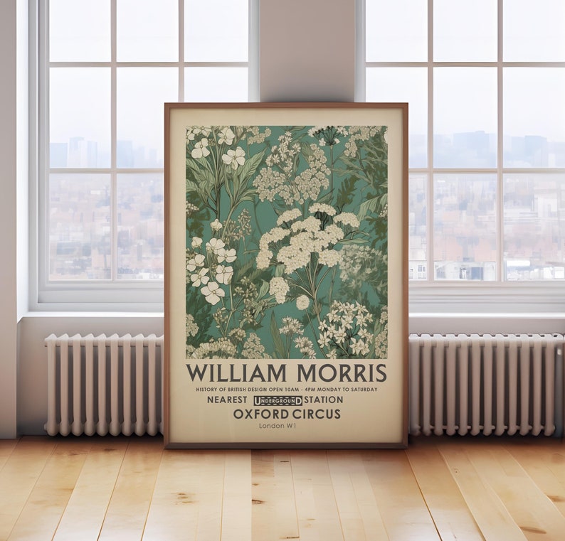 May include: A framed art print featuring a floral design in shades of teal, white, and green. The print includes the text "WILLIAM MORRIS" and details about the history of British design, the nearest Underground station, and the location in London.