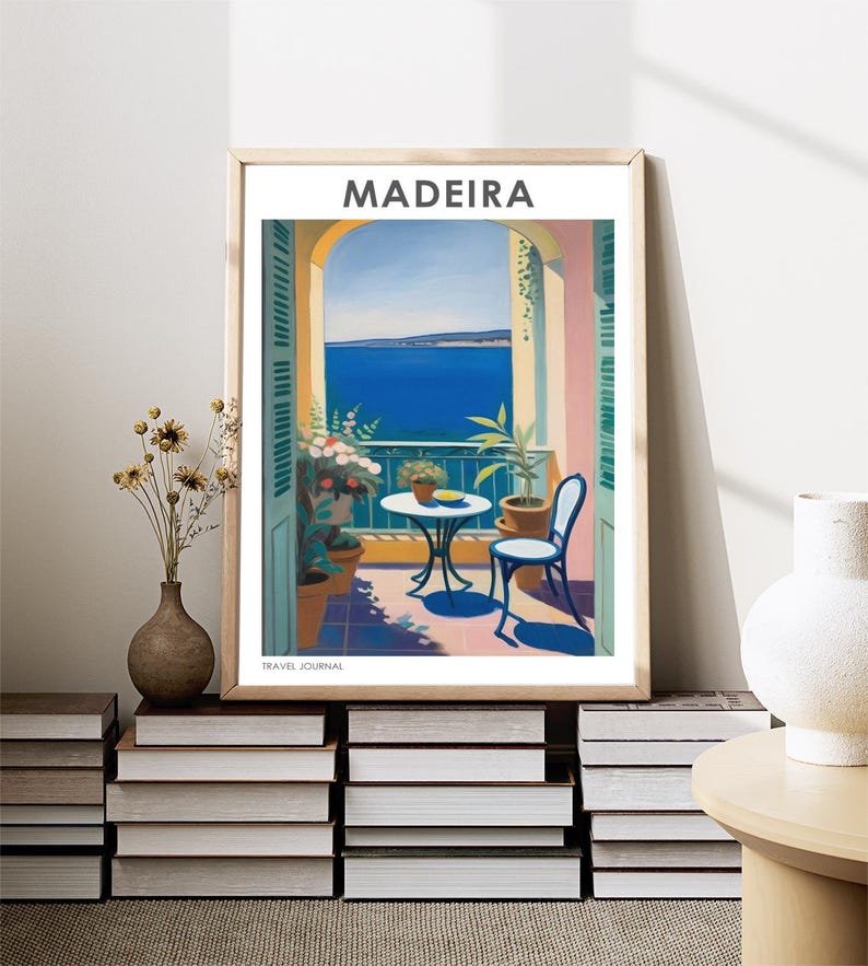 May include: A vintage travel poster with a painting of a balcony overlooking the ocean. The poster is titled "MADEIRA TRAVEL JOURNAL" and features a table and chair on the balcony.