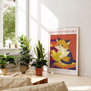 May include: A colorful poster with a cartoon cat reading a book. The poster has the text "Busy with Books" and "Wake up and read" in a red and white font.