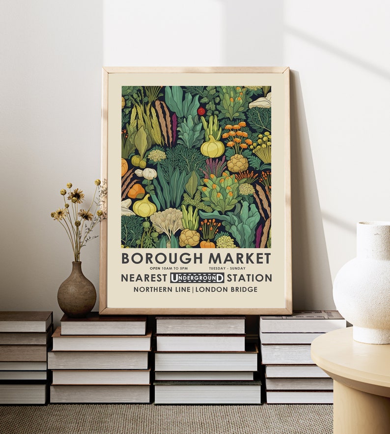 Puede incluir: Un p&oacute;ster enmarcado con una colorida ilustraci&oacute;n de verduras. El p&oacute;ster incluye el texto "BOROUGH MARKET" y detalles sobre la estaci&oacute;n de metro m&aacute;s cercana en Londres. La obra de arte se muestra sobre una pila de libros.