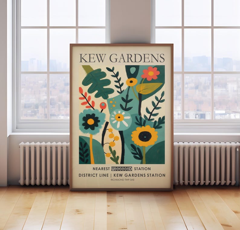 May include: A framed art print featuring a colorful floral design with the text "KEW GARDENS" at the top. The artwork includes various flowers and foliage in shades of blue, yellow, and red. The bottom text reads "NEAREST UNDERGROUND STATION DISTRICT LINE | KEW GARDENS STATION".